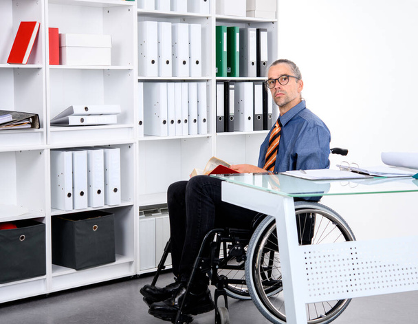 disabled business man in wheelchair working  in the office - Zdjęcie, obraz