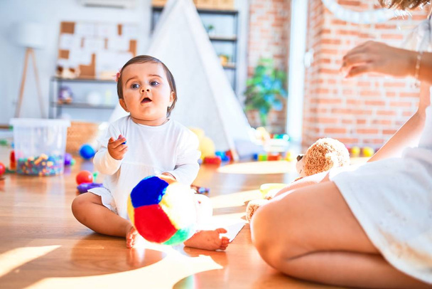 Hermoso bebé feliz en el jardín de infantes alrededor de juguetes coloridos
 - Foto, imagen