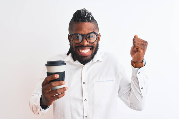 Afrikanische amerikanische Geschäftsmann mit Zöpfen Kaffee trinken über isolierten weißen Hintergrund schreien stolz und feiern Sieg und Erfolg sehr aufgeregt, jubelnde Emotion - Foto, Bild