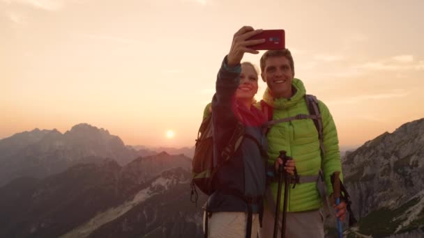 SLOW MOTION: Newlyweds taking selfies after reaching the mountaintop at sunrise. - Footage, Video