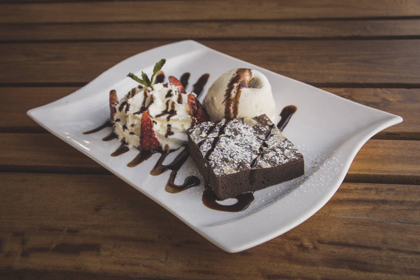 Chocolate brownies With whip cream and ice cream isolate on wood table - Fotografie, Obrázek