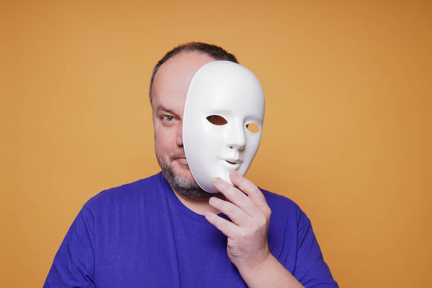 man taking off mask revealing face and identity - Фото, зображення