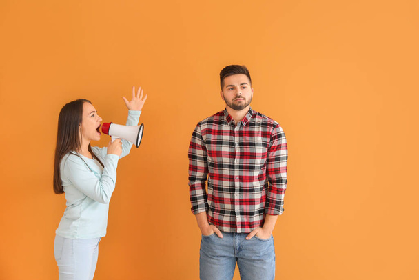 Розлючена жінка з мегафоном кричить на її чоловіка на кольоровому фоні
 - Фото, зображення