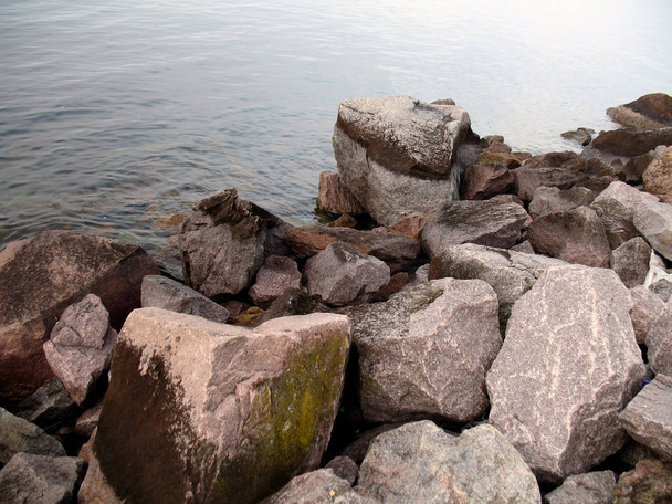 large stones on the river bank, calm water, shore, close-up - 写真・画像