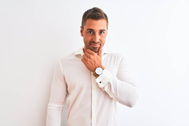 Young handsome business man wearing elegant shirt over isolated background looking confident at the camera with smile with crossed arms and hand raised on chin. Thinking positive. - Photo, Image