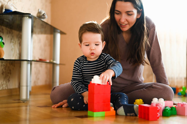 Mamãe desenvolve seu filho com brinquedos. O futuro construtor. menino e mãe jogar com um brinquedo
 - Foto, Imagem