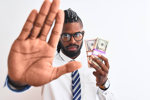 Afro-amerikai üzletember a zsinórra gazdaság dollár több mint elszigetelt, fehér háttér nyitott kézzel csinálás stop jel komoly és magabiztos kifejezés, védelmi gesztus - Fotó, kép