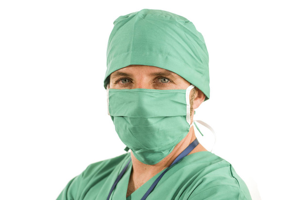 Krankenhauspersonal Unternehmensporträt eines attraktiven und erfolgreichen Mediziners, der selbstbewusst in grüner medizinischer Kleidung und Schutzmaske und Straußmütze lächelt - Foto, Bild