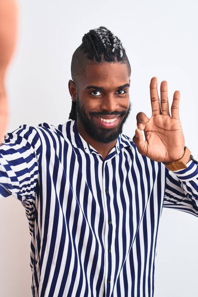 Africano americano homem com tranças fazer selfie por câmera sobre fundo branco isolado fazendo ok sinal com os dedos, excelente símbolo
 - Foto, Imagem