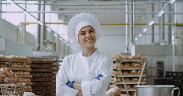 Kaupalliset kasvot hämmästyttävä nainen leipuri katselee suoraan kameraan
 - Valokuva, kuva