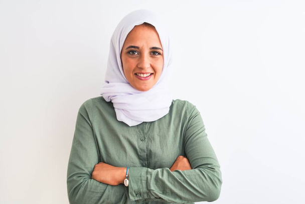 Молода арабка, одягнена в традиційного мусульманського хіджабу, радісно посміхається з перехрещених рук, дивлячись на камеру. Позитивна людина. - Фото, зображення