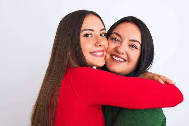 Young beautiful friends smiling happy and confident wearing casual clothes. Standing with a smile on face hugging over isolated white background - Fotó, kép