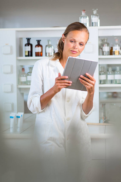 Portrait of a female researcher doing research in a lab, using a tablet computer for data collection and visualization(shallow DOF - Fotó, kép