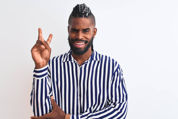 African american man with braids wearing striped shirt over isolated white background smiling with happy face winking at the camera doing victory sign. Number two. - Fotoğraf, Görsel