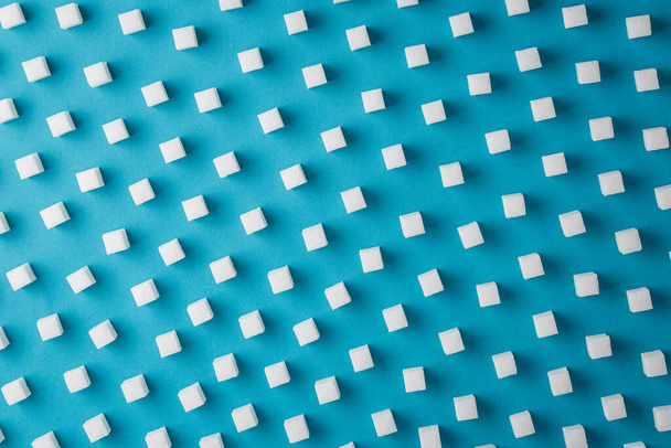 Suiker geraffineerd patroon op een blauwe achtergrond. - Foto, afbeelding