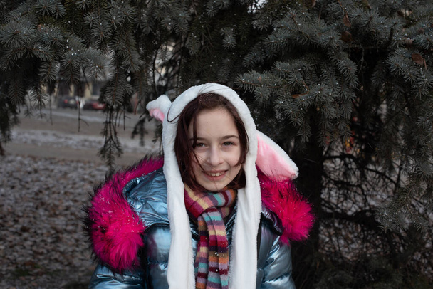 aranyos kislány csuklyában fülekkel. lány egy kalap nyuszi utcában - Fotó, kép