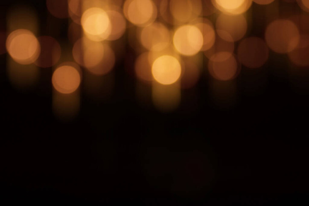 Black christmas background with blurred gold bokeh - Foto, Imagen