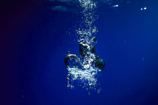 Ледяной куб падает в воду, крупным планом
  - Фото, изображение