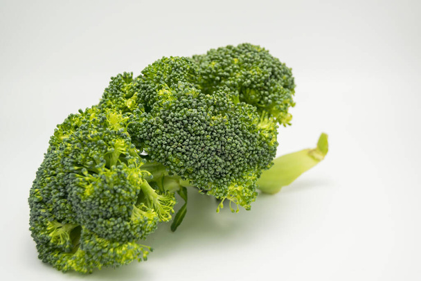 Nahaufnahme von grünem Brokkoli auf weißem Hintergrund  - Foto, Bild