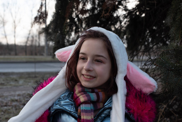 Милая маленькая девочка в капюшоне с ушами. девушка в шляпе кролика
 - Фото, изображение