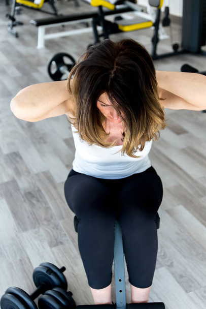 mujer joven haciendo ejercicios con pesas en el gimnasio - Foto, imagen