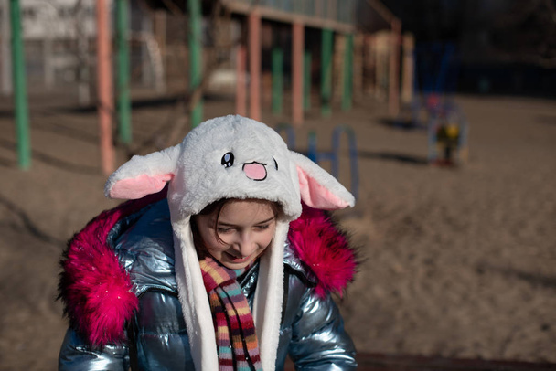 Leuk klein meisje met een kap en oren. meisje in een hoed bunny straat - Foto, afbeelding
