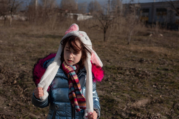 Χαριτωμένο κοριτσάκι με κουκούλα και αυτιά. κορίτσι σε μια οδό λαγουδάκι καπέλο - Φωτογραφία, εικόνα