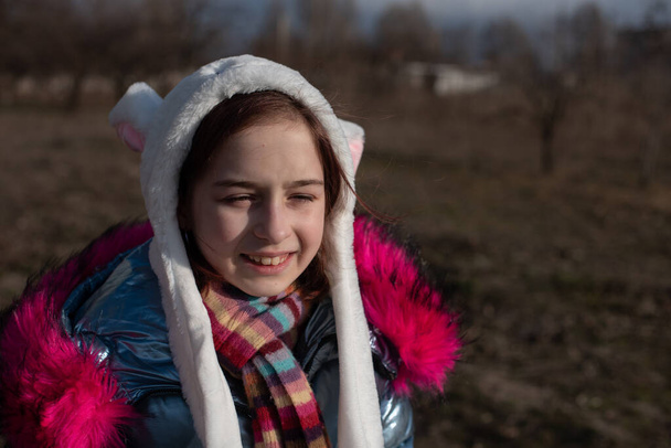 roztomilá holčička v kapuci s ušima. dívka v klobouku králík ulice - Fotografie, Obrázek