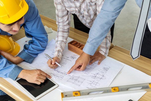 A group of engineers are looking at a blueprint for construction - Foto, afbeelding