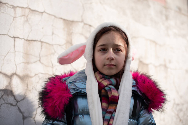 мила маленька дівчинка в капюшоні з вухами. дівчина в капелюсі кролика вулиці
 - Фото, зображення