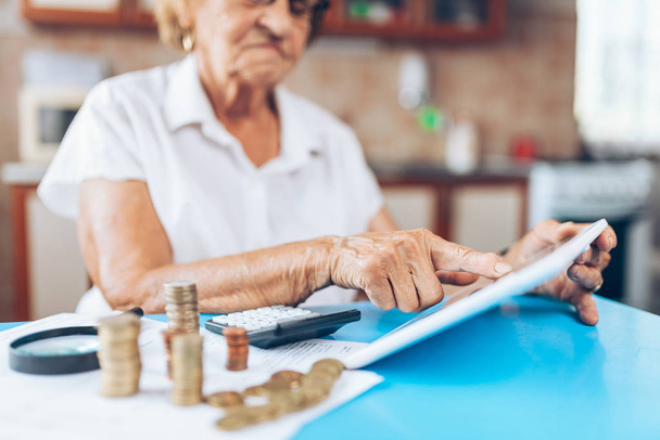 Senior woman at home checking her finances and invenstments - Valokuva, kuva