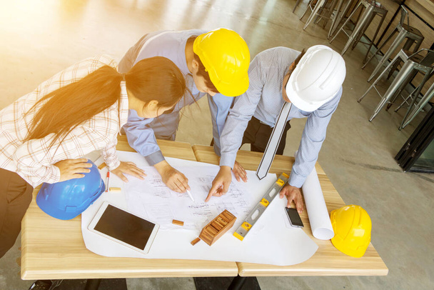 A group of engineers are looking at a blueprint for construction - Фото, изображение