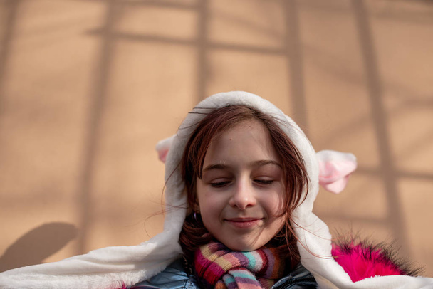 carina bambina in cappuccio con le orecchie. ragazza in un cappello coniglietto strada
 - Foto, immagini