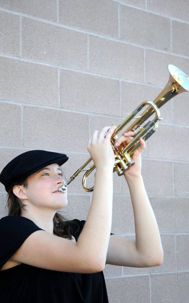 Female jazz trumpet player blowing her horn outside. - 写真・画像