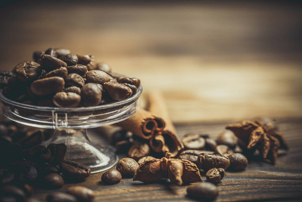 A lot of fragrant coffee beans on a plastic stand on a wooden table - Photo, Image