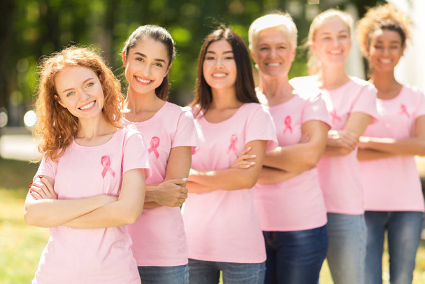 Frauen in pinkfarbenen T-Shirts stehen im Park, flach - Foto, Bild