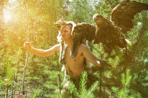 hombre primitivo en la caza del bosque con sentado en el brazo de un
 - Foto, Imagen