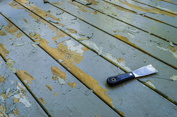 Úhlový pohled na tmel nůž ležící na šedé dřevěné desky vedle t - Fotografie, Obrázek