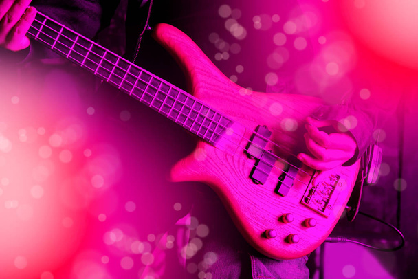 Life style image of close up young man hand, playing electric bass guitar - 写真・画像