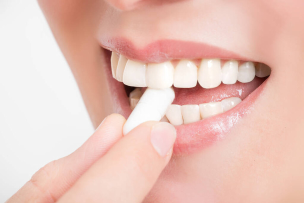 Film tablet between the teeth of a woman - Foto, imagen