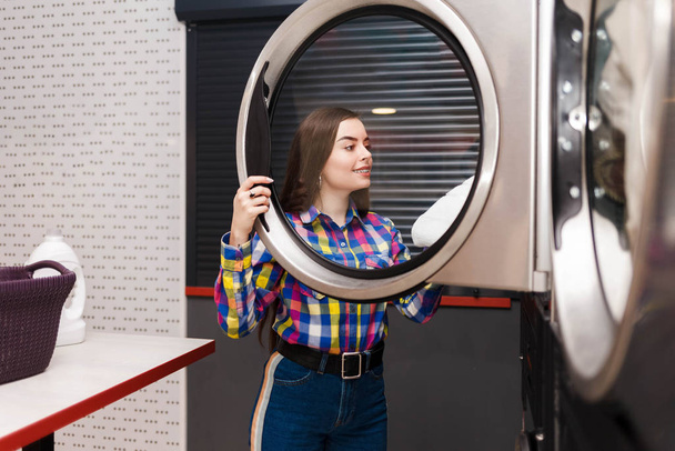 самообслуговування клієнт прання виймає речі з сушарки
 - Фото, зображення