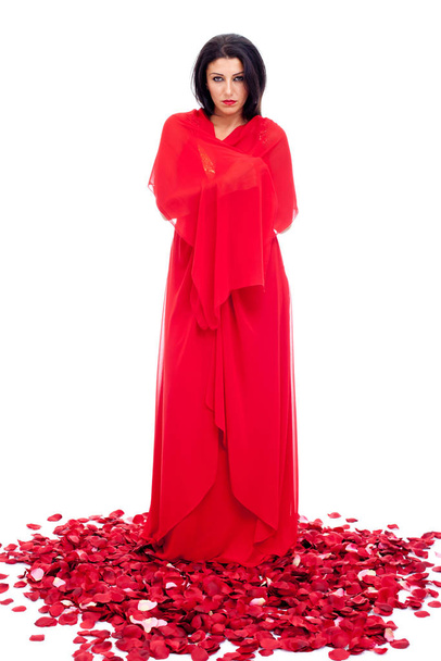 krásná mladá žena v červených šatech s okvětními lístky růží izolované na bílém - Fotografie, Obrázek