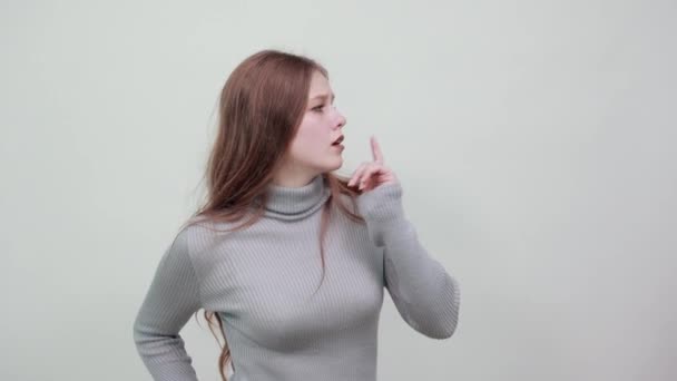 Frau im grauen Pullover denkt über neue Idee nach, Zeigefinger vor Mund zu halten - Filmmaterial, Video