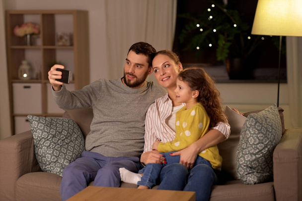 happy family taking selfie at home at night - Foto, Imagem