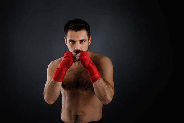 boxer man shows the different movements on black background - Photo, Image