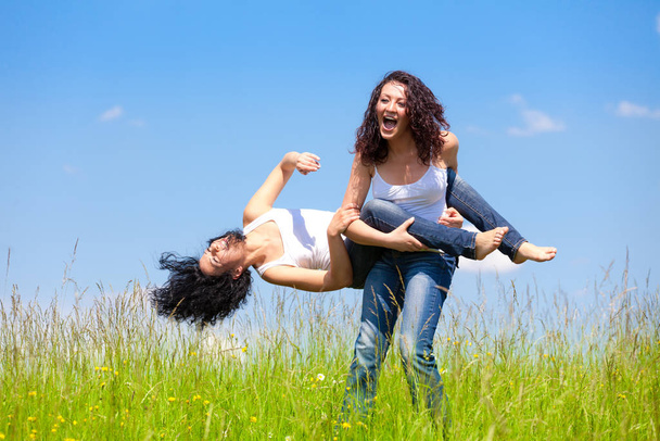 Two woman are playing on the summer meadow - Foto, immagini