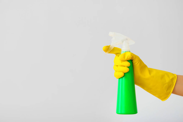 Hand des Hausmeisters mit Waschmittel auf hellem Hintergrund - Foto, Bild