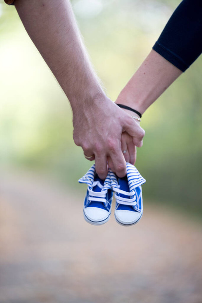 Hands holding blue Babyshoes - Foto, imagen