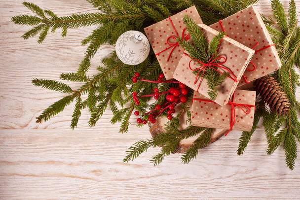 Still life with gift boxes, fir tree branches and christmas decorations on a wooden background.Top view with copy space. Christmas and New Year - Fotó, kép