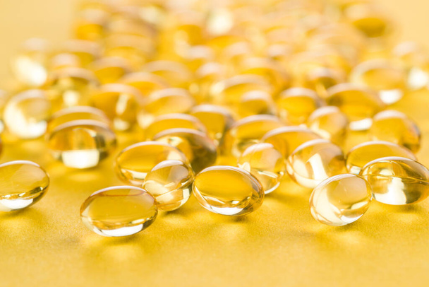 Omega 3 gel capsules. Fish oil pills. Healthy omega-3 on yellow background. - Foto, Imagem